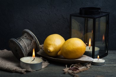 Still life with three lemons and coffee mill. Dark style